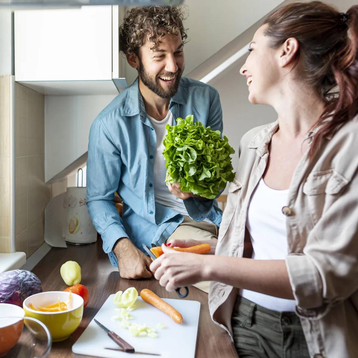 a man and a woman cooking a healthy meal together