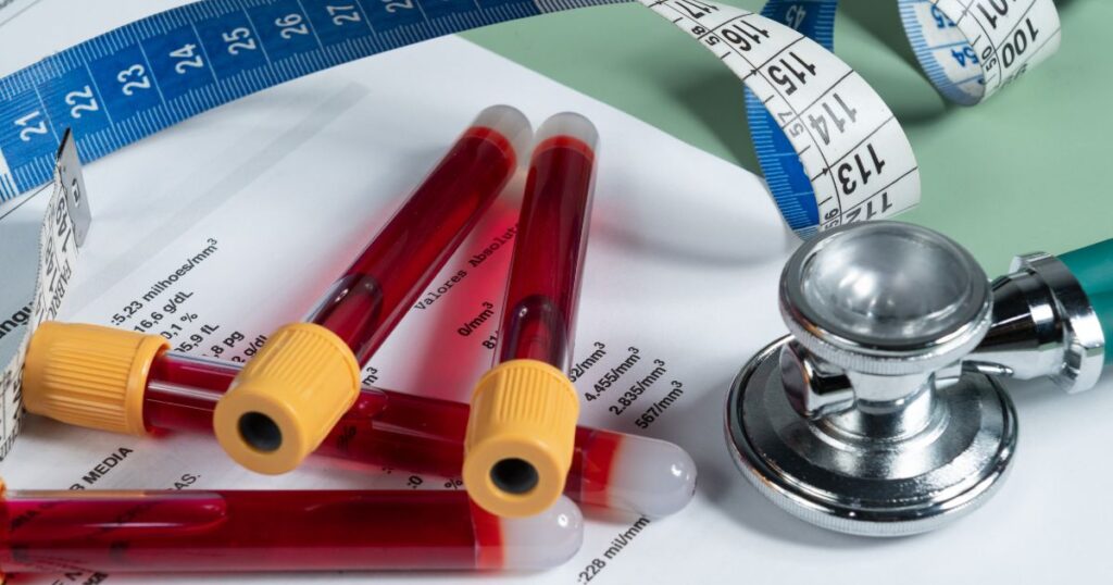 an image of blood test tubes, tape measure and stethoscope